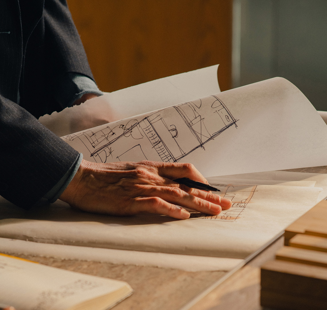 Hand on paper looking over building plans
